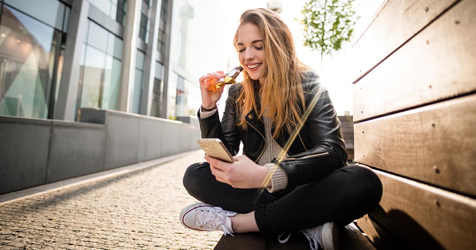 Woman on phone eating snack