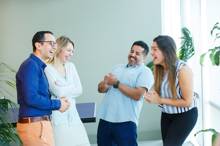 Group of four colleagues laughing