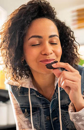 Woman enjoying Oreo cookie.